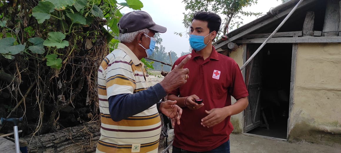 Nepal_RCS_4.jpg A Nepal Red Cross Society volunteer explains cash assistance to Gagan Singh, a recipient. © Nepal Red Cross Society