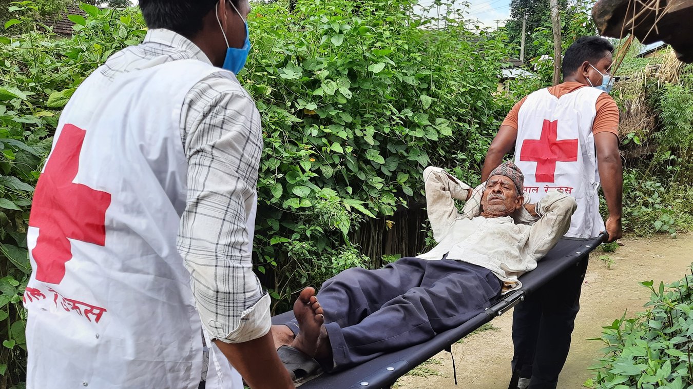 Nepal_RCS_feature_image.jpg A man is carried on a stretcher by two volunteers.
